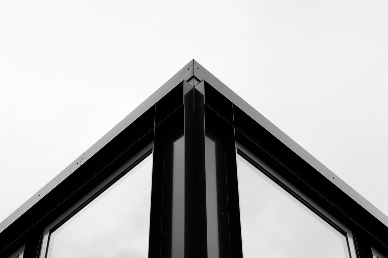 Puntgevel van zwart staal en glas van Units for U tegen een witte lucht