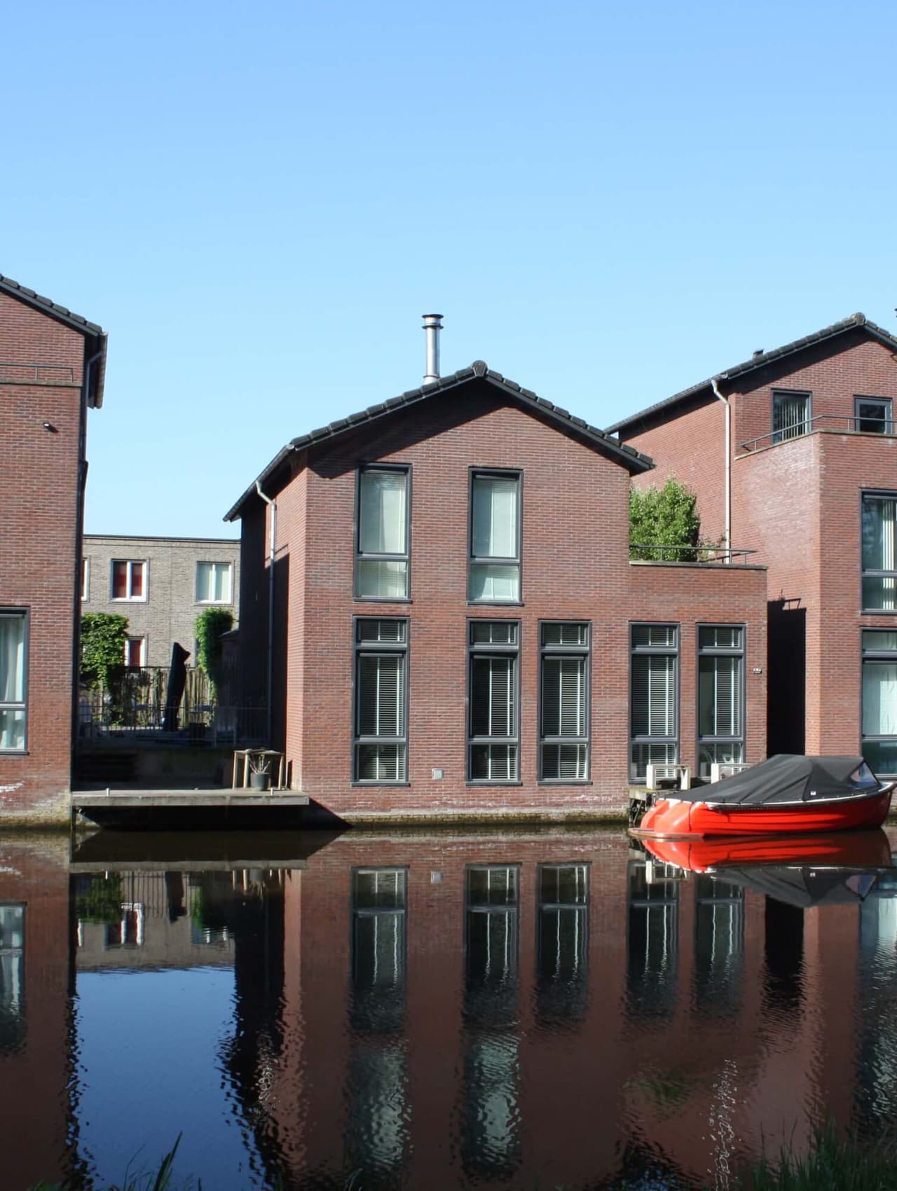 Woning aan het water in Vathorst met rode sloep voor de deur